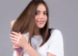 Woman brushing straight, toner-enhanced brown hair and smiling in Scottsdale, AZ.
