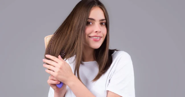 Woman brushing straight, toner-enhanced brown hair and smiling in Scottsdale, AZ.