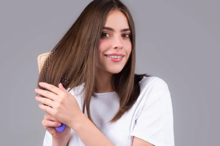 Woman brushing straight, toner-enhanced brown hair and smiling in Scottsdale, AZ.