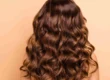 Professional hair color correction results showing healthy, shiny, wavy brown hair from the back in Scottsdale, AZ
