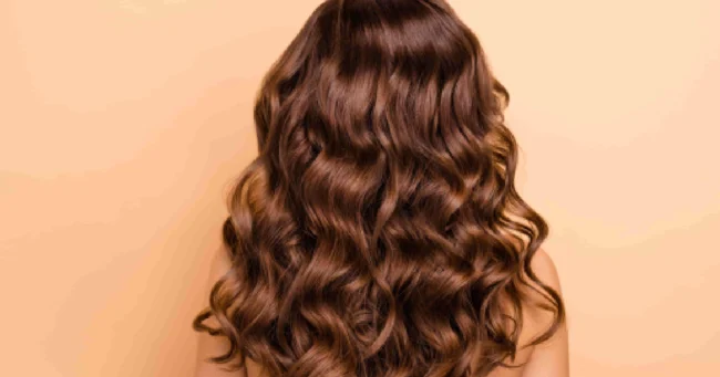Professional hair color correction results showing healthy, shiny, wavy brown hair from the back in Scottsdale, AZ